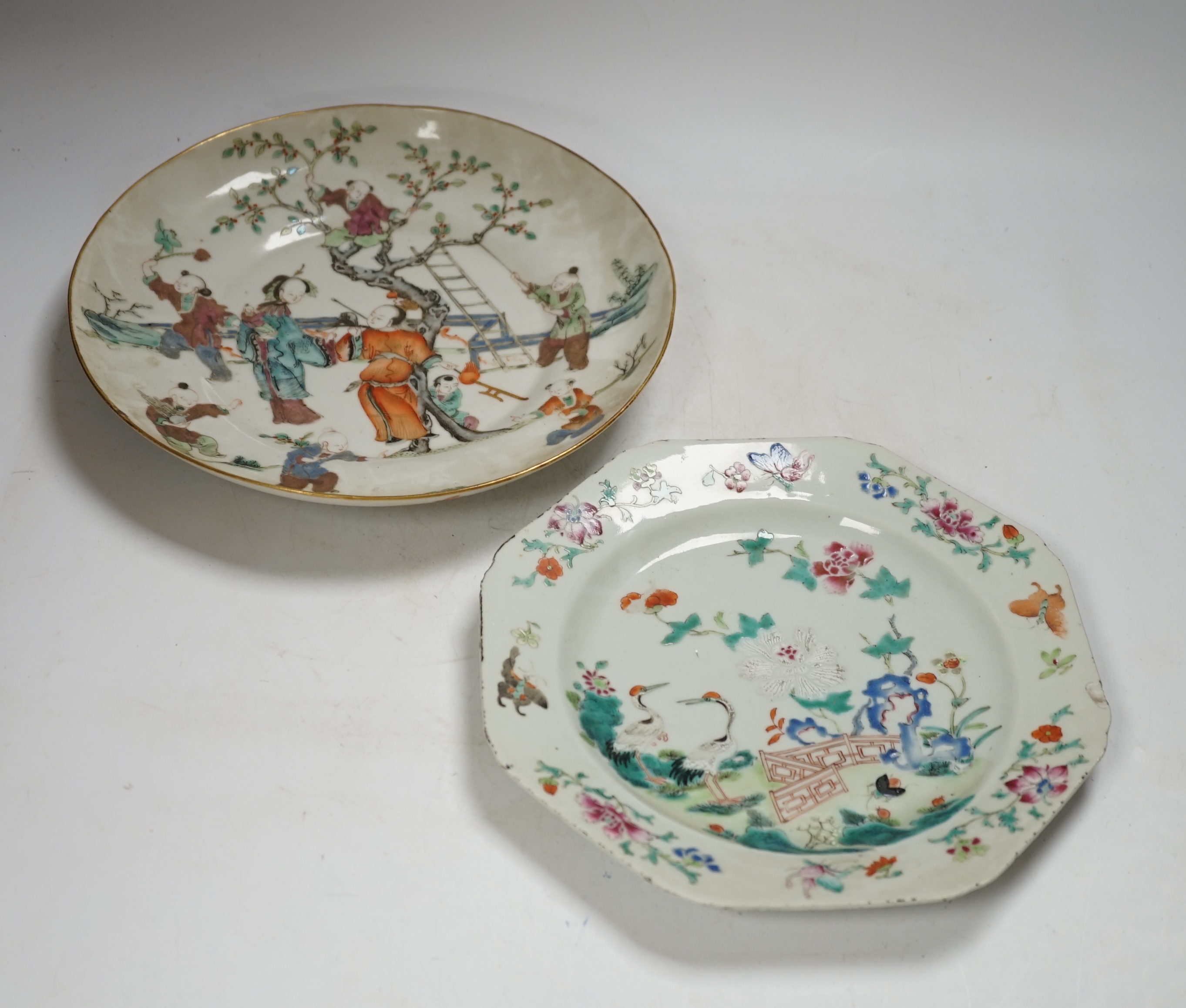 A Chinese famille rose ‘boys’ saucer dish, Tongzhi seal mark and probably of the period (1862-1874) and an 18th century Chinese famille rose octagonal ‘cranes’ plate, dish 25cm diameter